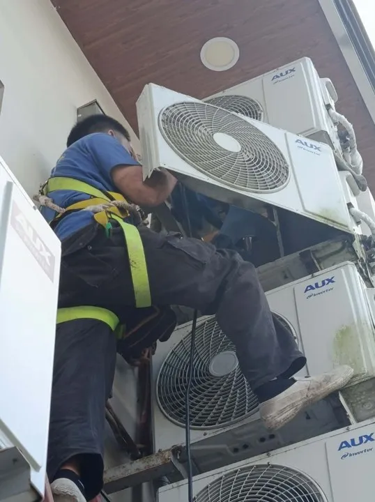 Technician servicing high rise outdoor units